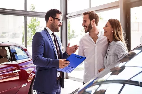 car salesman talking to a couple