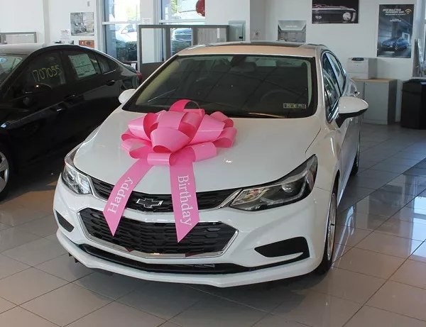 White car with happy birthday ribbon