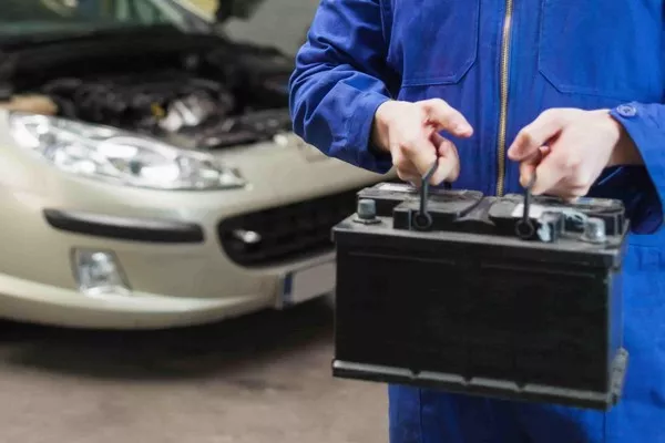 Mechanic holding a car battery