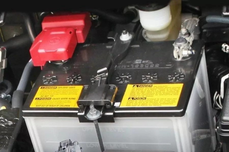 A picture of a car battery with a clamp