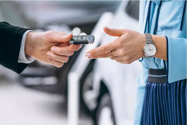 A picture of someone handing over car keys
