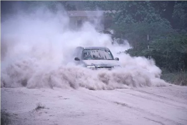 A picture of a car driving through volcanic ash