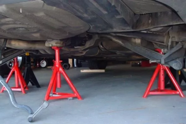 A picture of a car lifted by jack stands