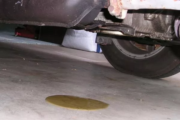 Periodically check under your car for leaks A picture of a garage with a car leak