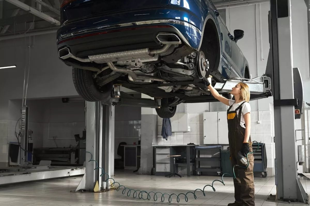 A picture of a mechanic lifting a car using a hydraulic lifter