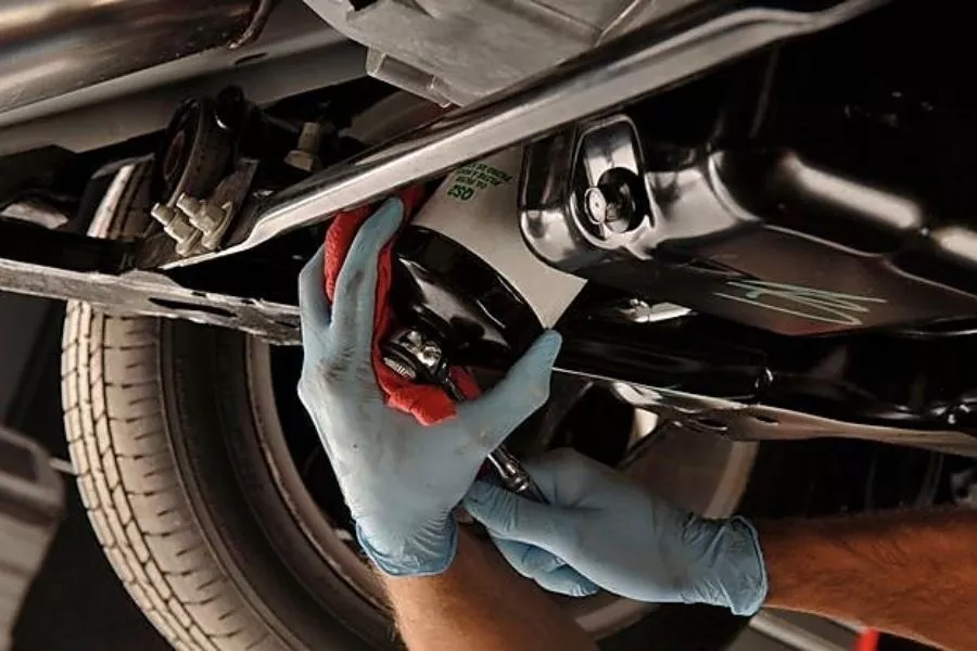 A picture of a mechanic replacing car oil filter