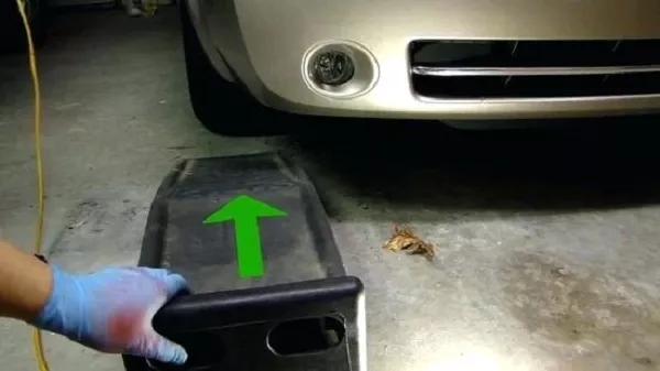 Man sliding the car ramp in front of tire