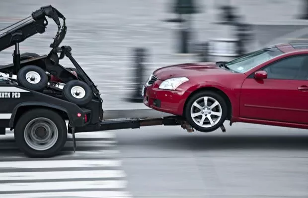 A picture of a tow truck towing a car