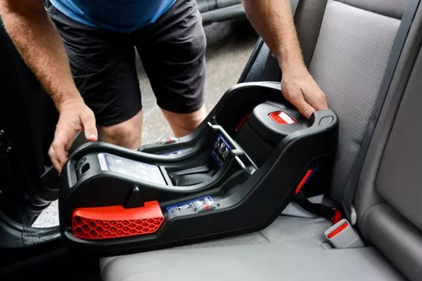 man installing baby car seat