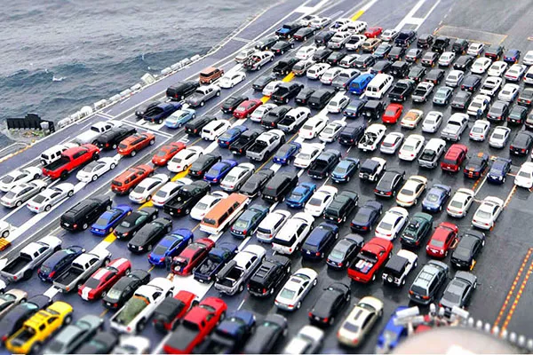 A picture of a cargo ship carrying brand new cars