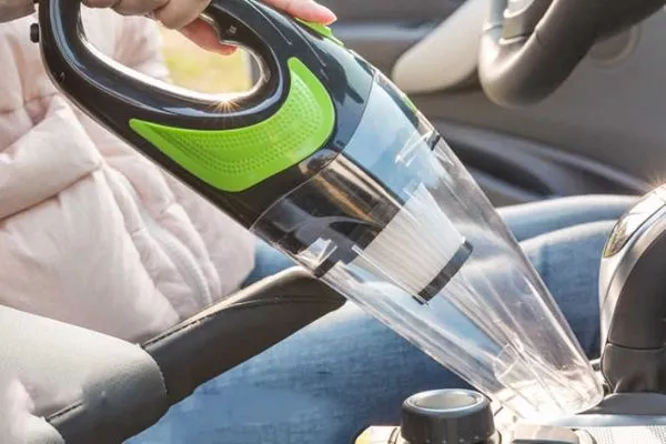 A picture of a person vacuuming a car