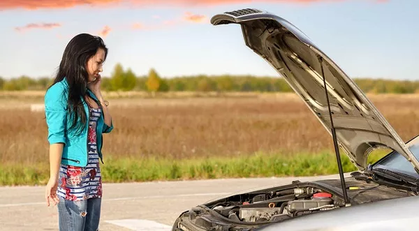 A women by her non-starting car.