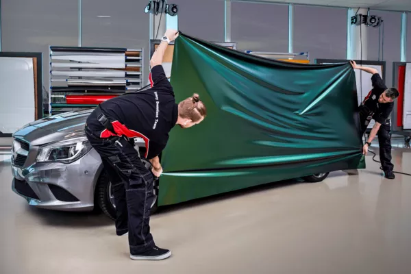 Two person holding a car wrapping material