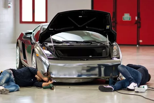 two men wrapping a car