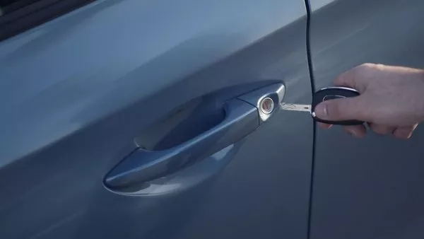 A person using a key in his/her car
