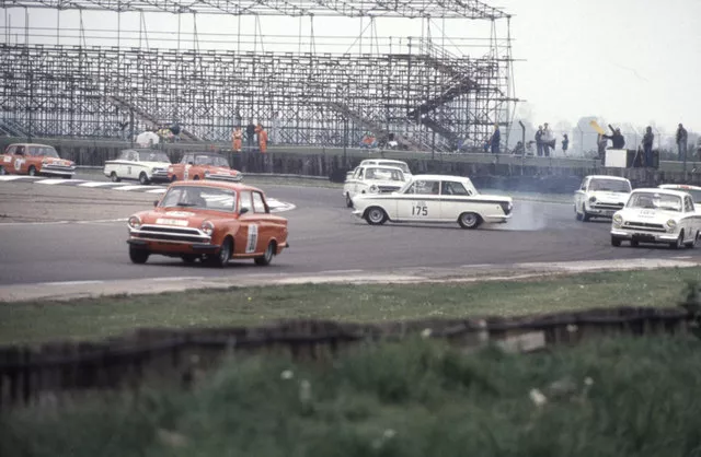 A car race scene with one car losing control because of lift-off oversteer.