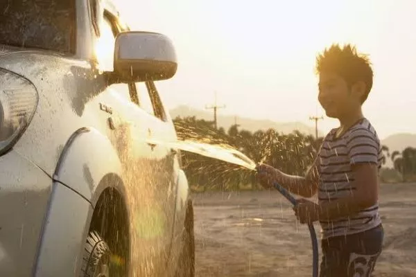 A boy washing a car