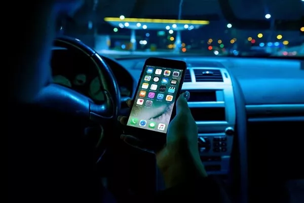 Check if the cause is external accessories like phones Man using mobile phone inside the car