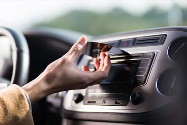 Driver putting CD on the car stereo