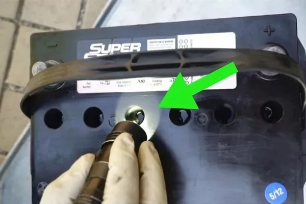 Using a flashlight to check the fluid level of each cell.