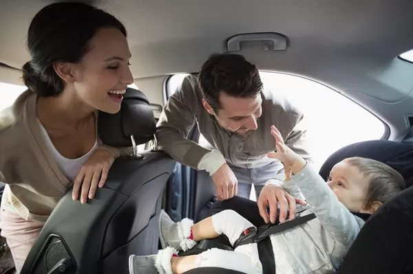 child and parents in car