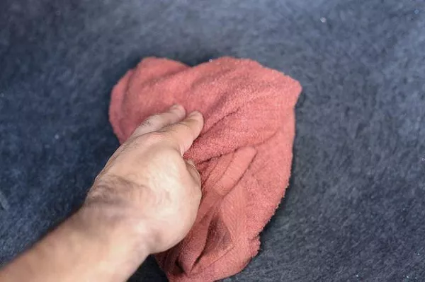 Man wiping the trunk carpet