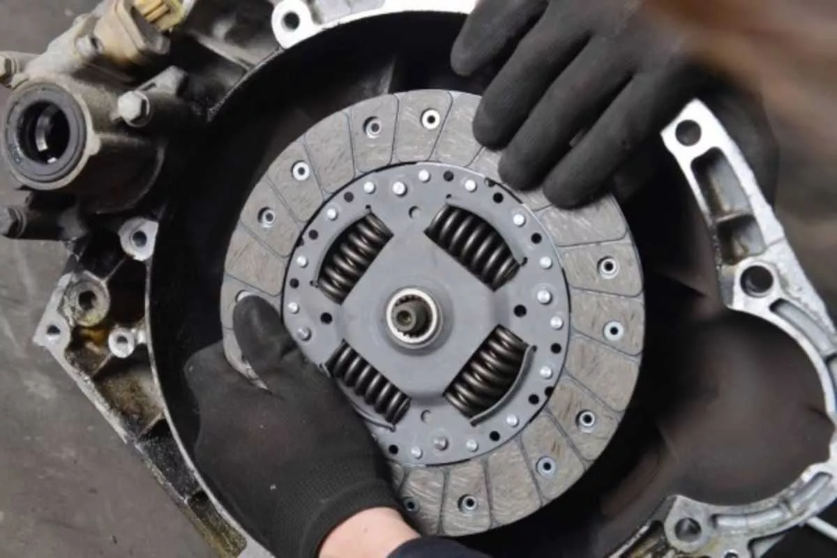 A picture of a man replacing a car's clutch