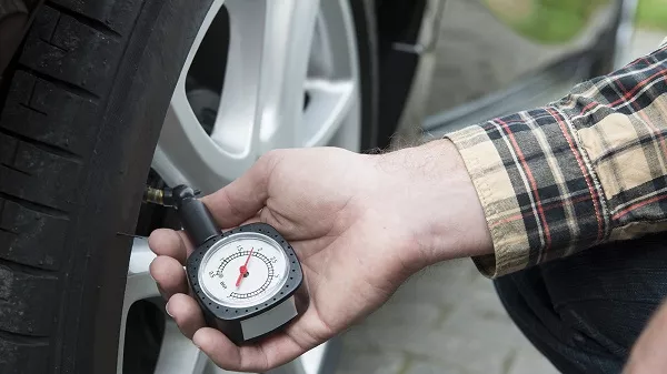 man measuring tire pressure