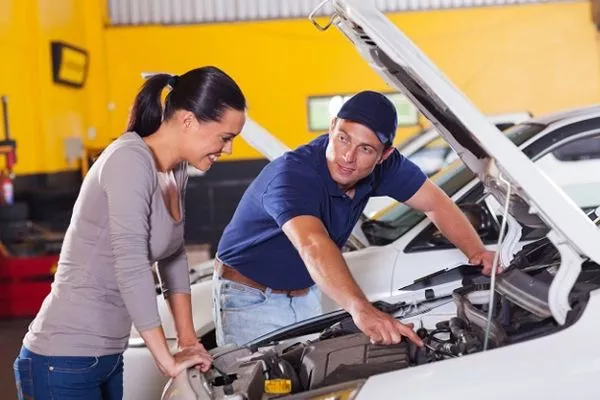 A picture of a woman and a car mechanic