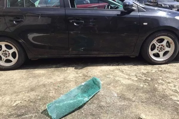 A picture of a car with damaged window caused by exploding bottle of alcohol.