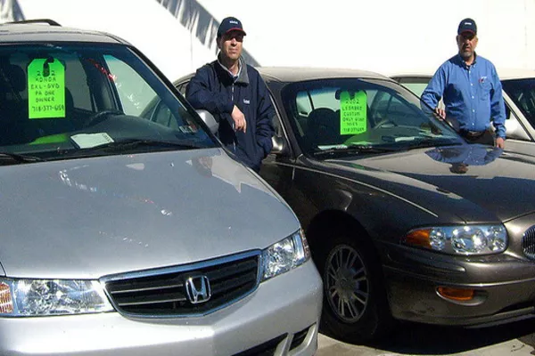 Car dealers beside the cars 