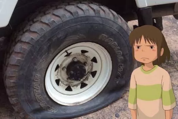 A picture of a girl disappointed at a flat tire.