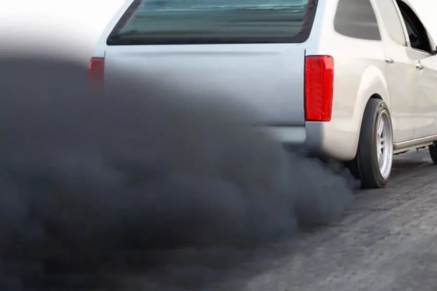 A picture of a pick-up truck spewing dark exhaust gases