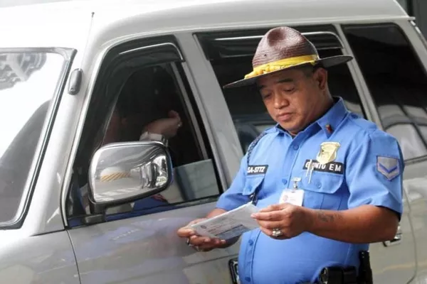 Filipino police officer checking on a driving w/out license case