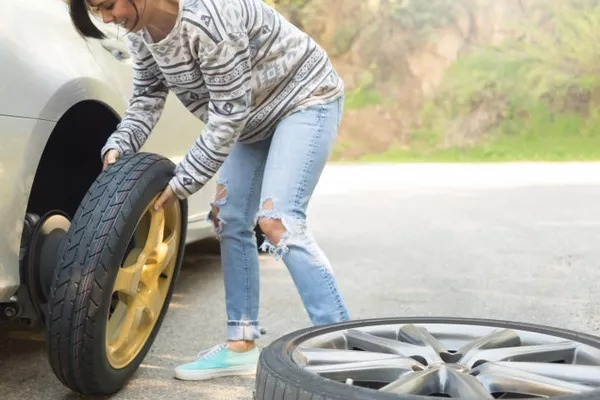woman changing tires 