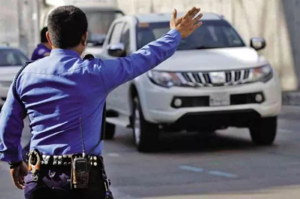 A police waving a car on the road