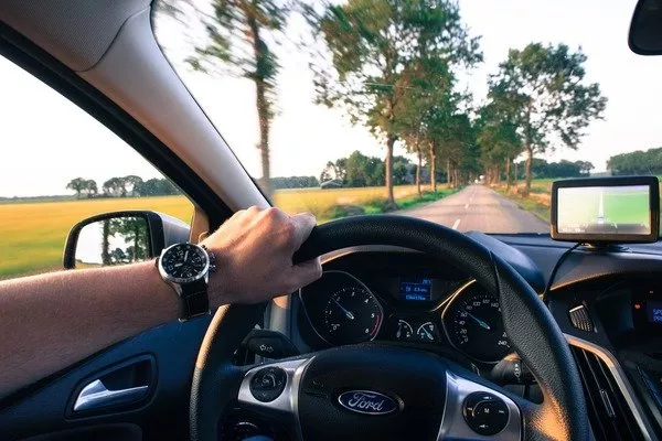 Person holding a steering wheel with one hand