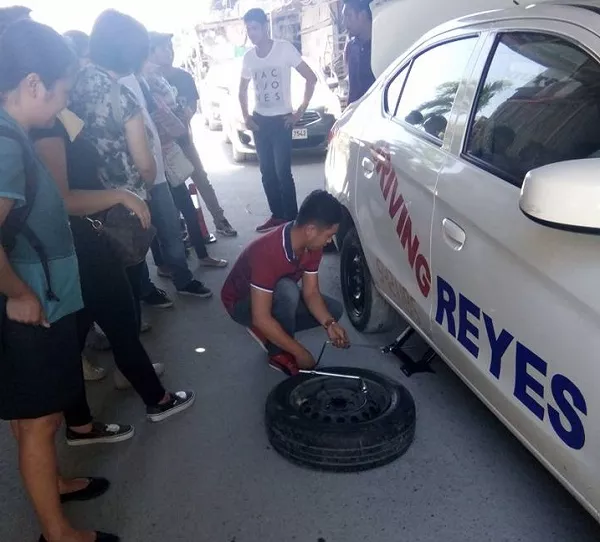 Reyes Driving Institute also conducts seminars on basic car maintenance as seen here A picture of a Reyes Driving Institute instructor demonstrating how to change a tire