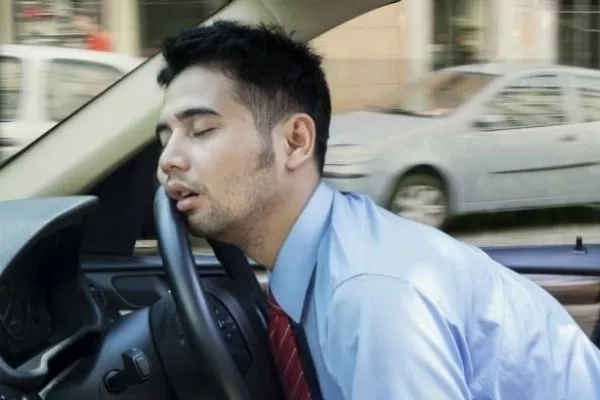 A picture of a man sleeping on the wheel
