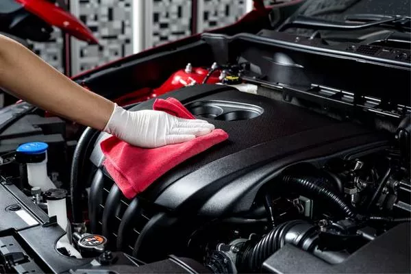 Man wearing gloves cleaning the engine