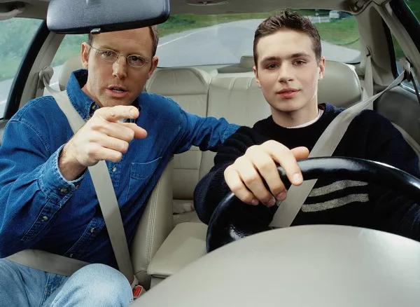 Man teaching the boy how to drive