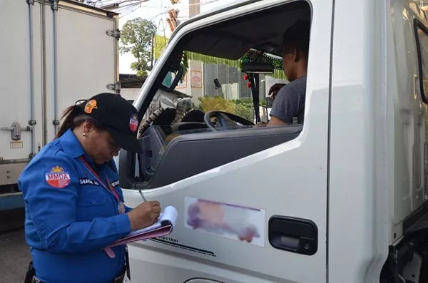 Traffic enforcer apprehending a truck driver