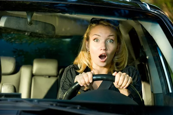 shocked woman behind the steering wheel