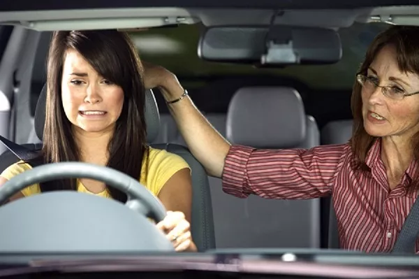 The most difficult step in overcoming the fear of driving is to actually get behind the wheel. Mom assist her daughter in driving