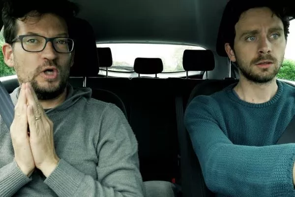 A picture of uncomfortable men in a car.