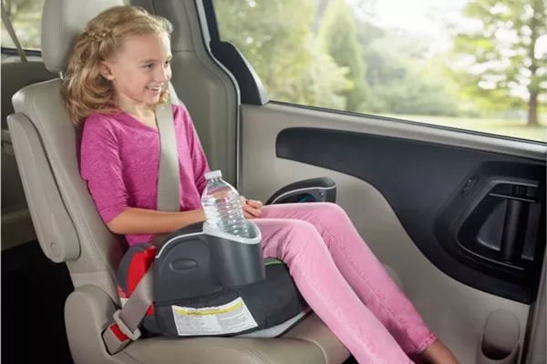 A kid inside the car seating on a booster seat 