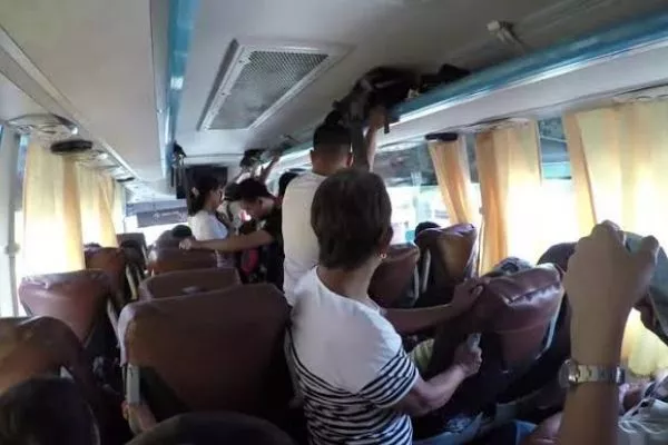 A picture of a bus in the Philippines full of passengers.