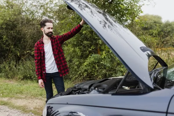 man looking at the car engine