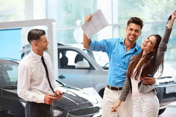 a couple buying a car in a dealership