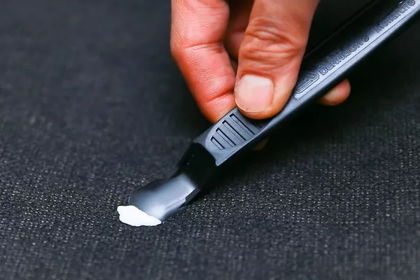 Man scraping the gum off the car seat